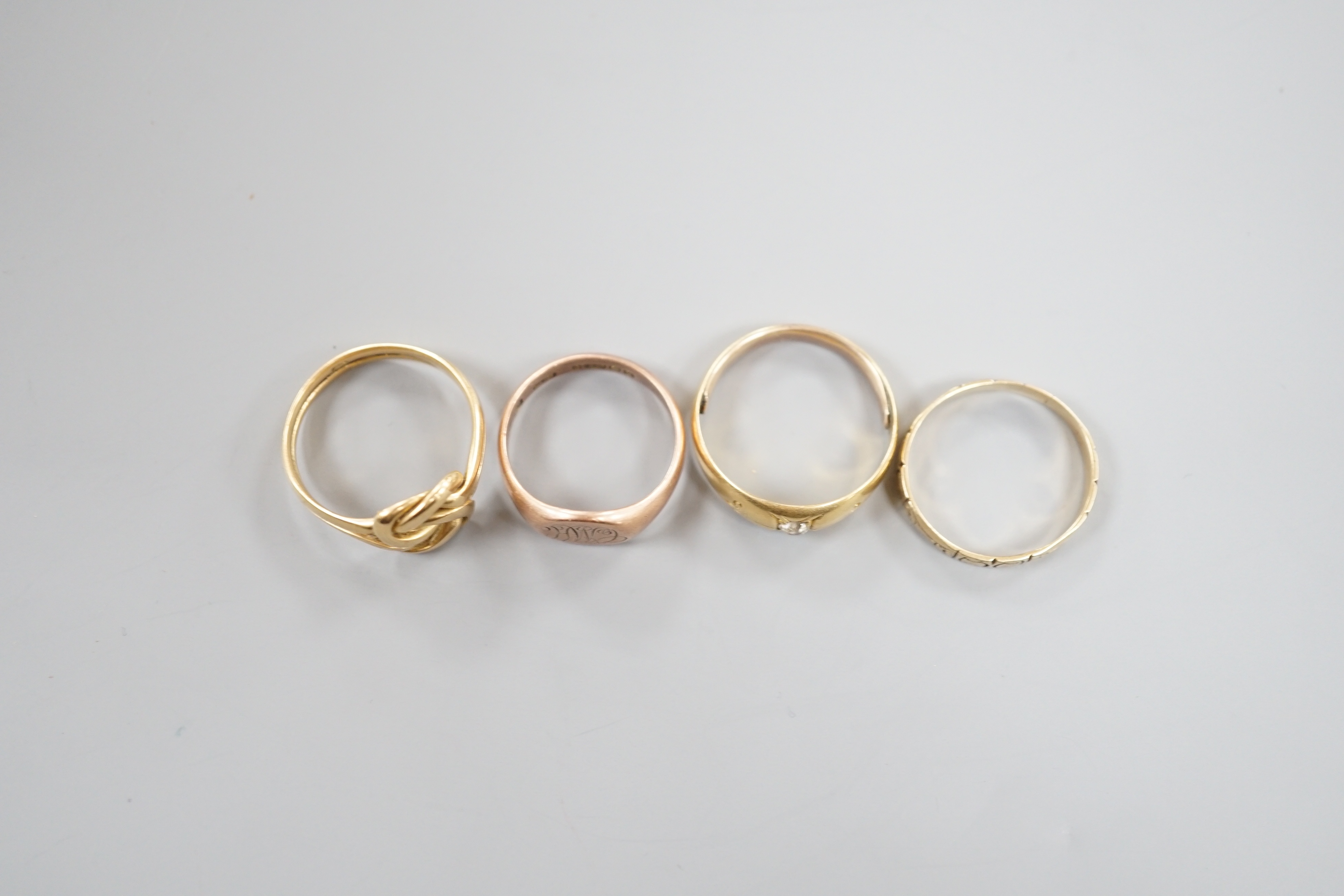 A George V 9ct gold signet ring. 3.6 grams and three other yellow metal rings, one set with a diamond, gross 11.4 grams.